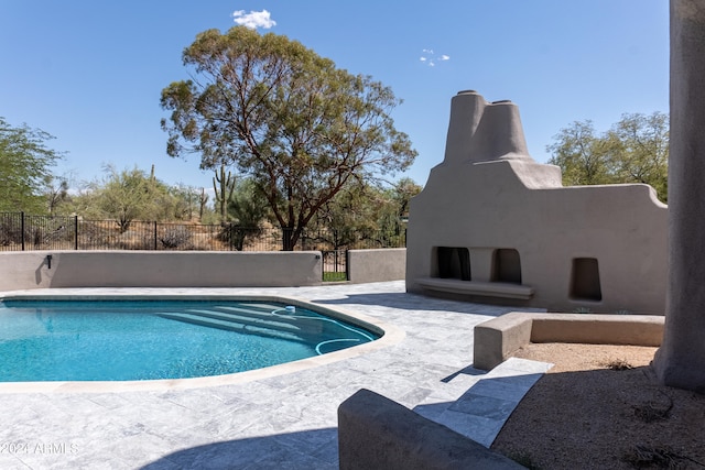 view of pool with an outdoor fireplace and a patio