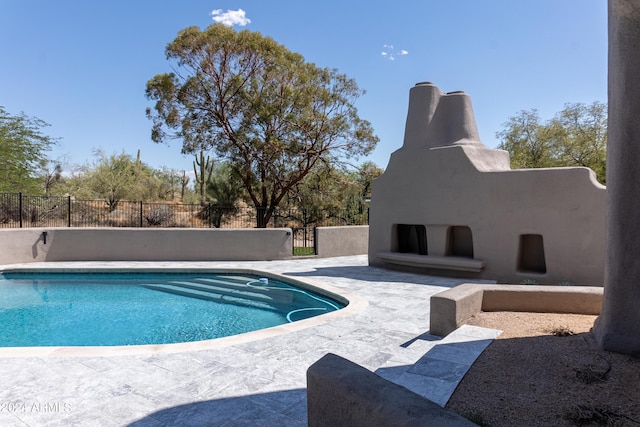 view of pool with a fireplace, a fenced in pool, fence, and a patio
