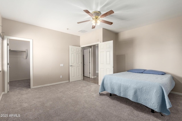 bedroom with baseboards, visible vents, a ceiling fan, carpet, and a spacious closet