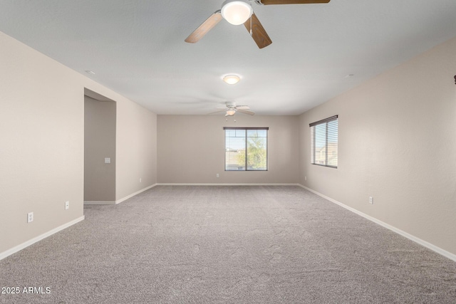 unfurnished room featuring carpet floors, ceiling fan, and baseboards