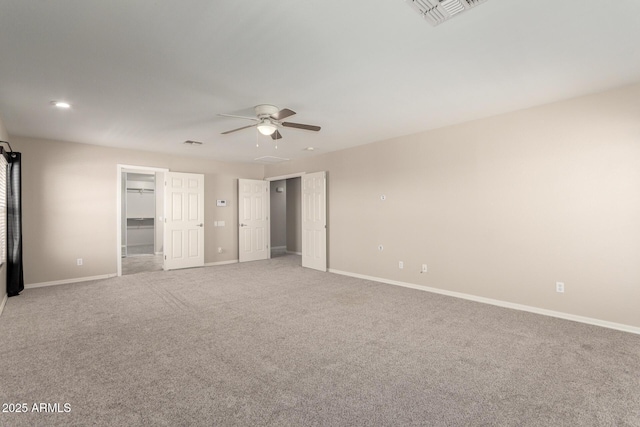 unfurnished bedroom featuring visible vents, light carpet, baseboards, and a spacious closet