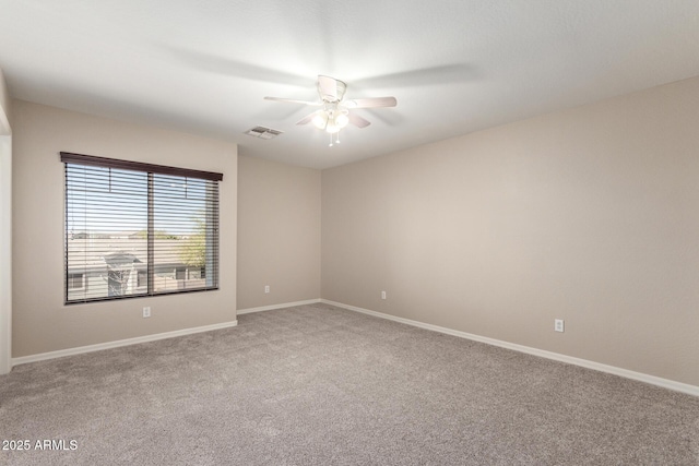 spare room with ceiling fan, light carpet, visible vents, and baseboards