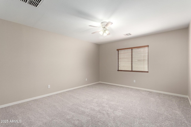 carpeted empty room featuring visible vents, ceiling fan, and baseboards