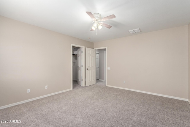 carpeted empty room with visible vents, ceiling fan, and baseboards