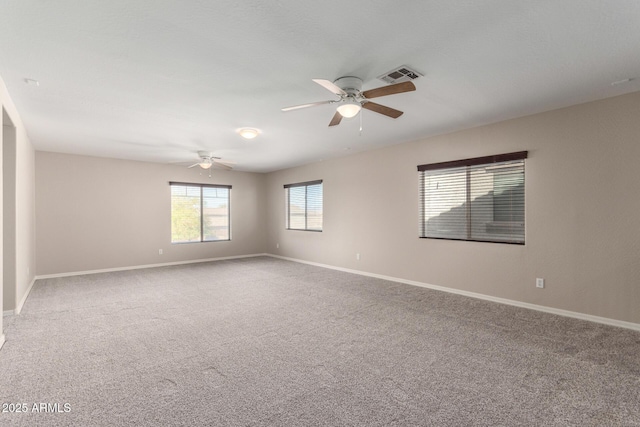 empty room featuring baseboards, visible vents, ceiling fan, and carpet flooring