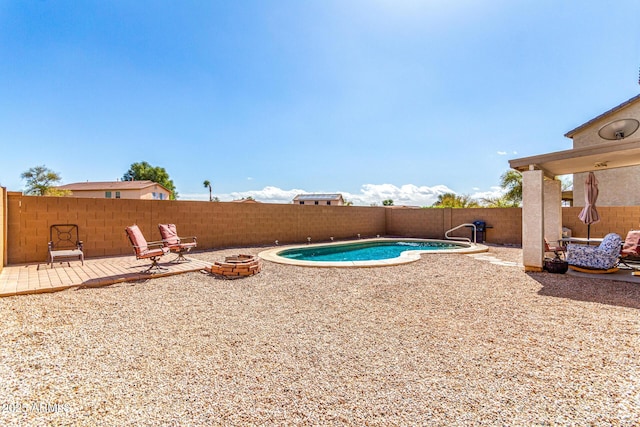 view of swimming pool with an outdoor fire pit, a patio area, a fenced backyard, and a fenced in pool