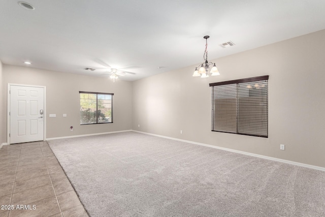 unfurnished room with light carpet, light tile patterned floors, baseboards, visible vents, and ceiling fan with notable chandelier