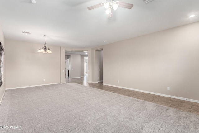 carpeted spare room with ceiling fan with notable chandelier, tile patterned floors, visible vents, and baseboards