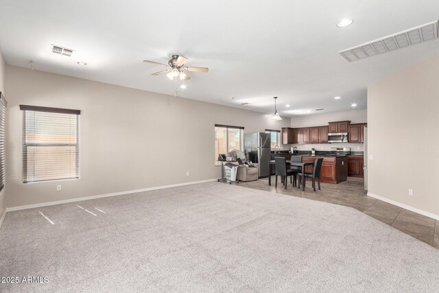 living area with recessed lighting, visible vents, and light carpet