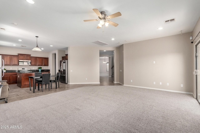 living area with recessed lighting, light colored carpet, visible vents, and baseboards