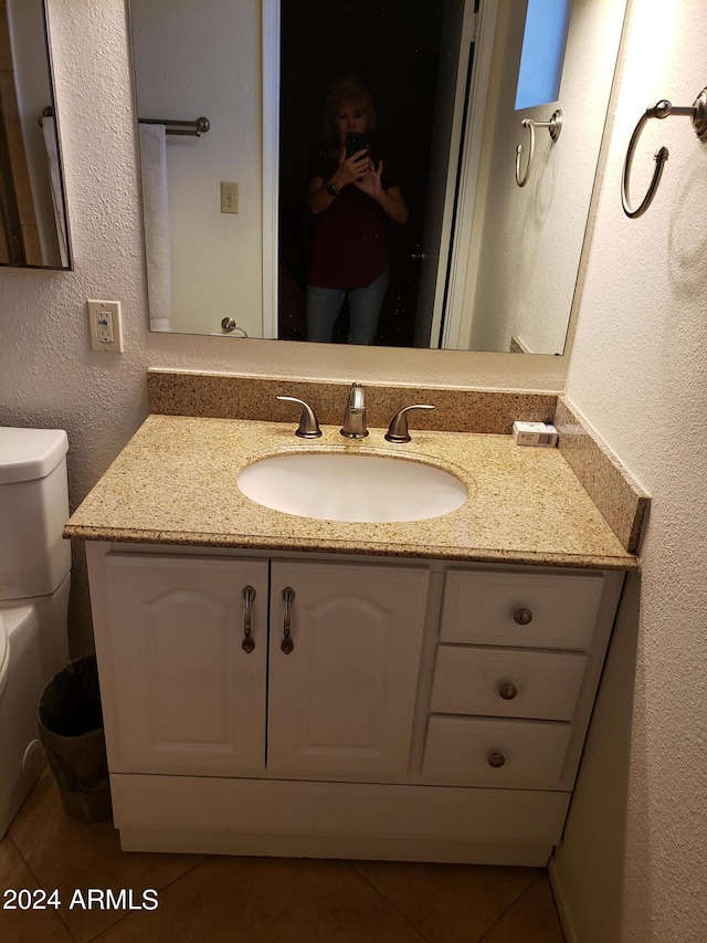 bathroom with tile patterned flooring, vanity, and toilet