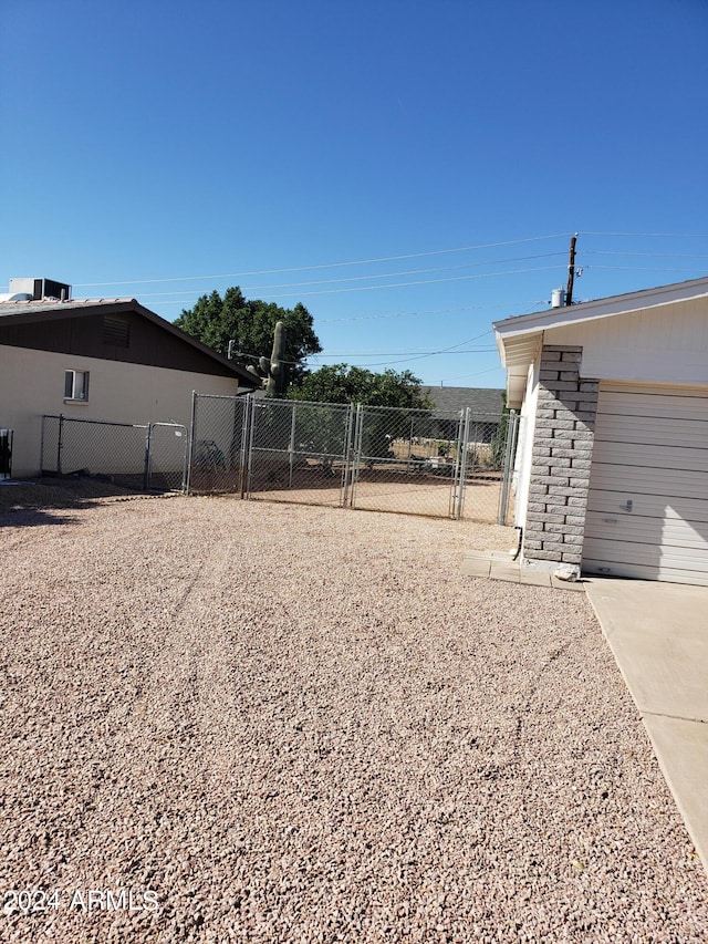 view of yard with central AC unit and a garage