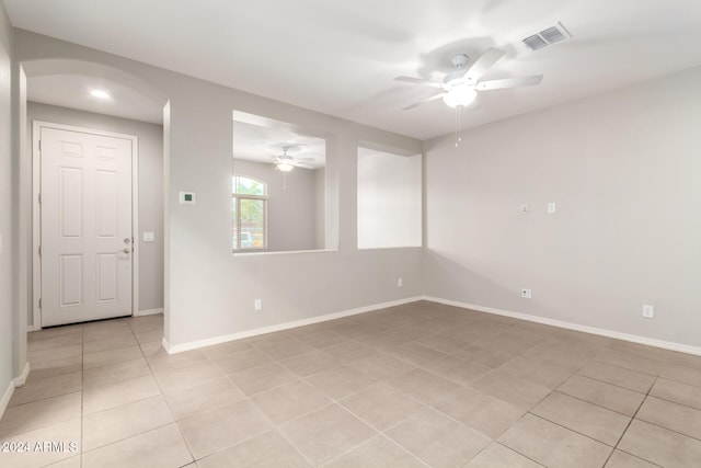 tiled spare room with ceiling fan