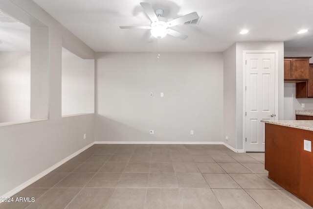 spare room featuring light tile patterned floors and ceiling fan