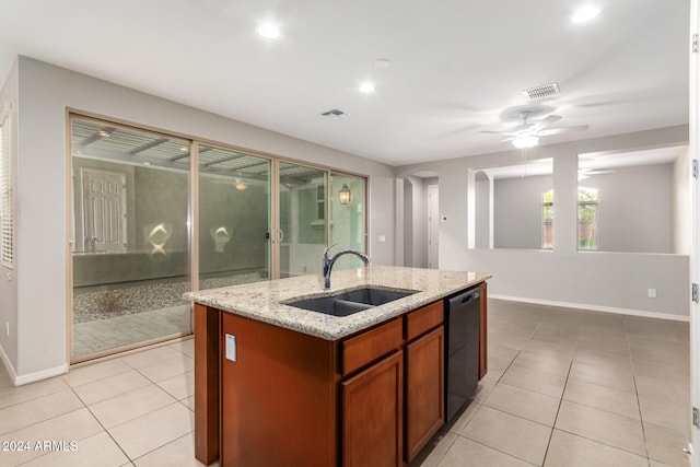 kitchen with dishwasher, sink, light stone counters, an island with sink, and light tile patterned floors