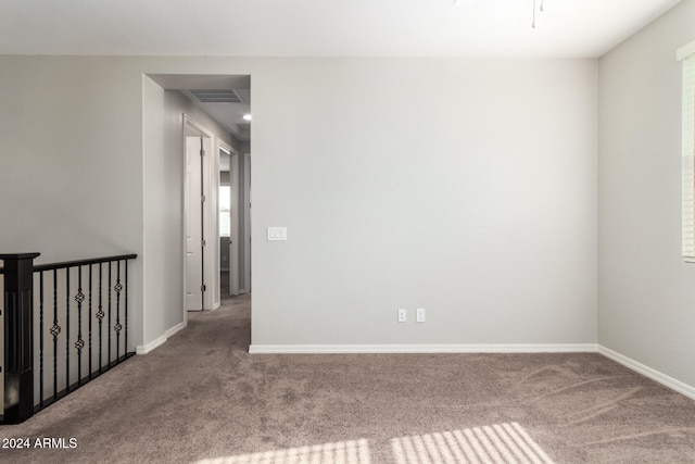 unfurnished room featuring a wealth of natural light and light colored carpet