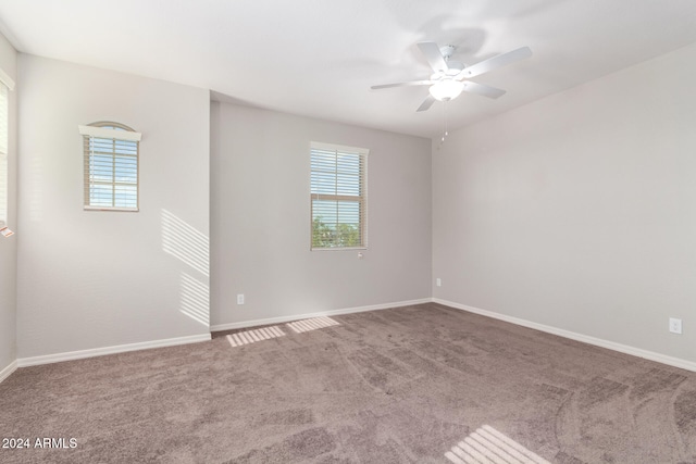 spare room featuring ceiling fan, a healthy amount of sunlight, and carpet floors