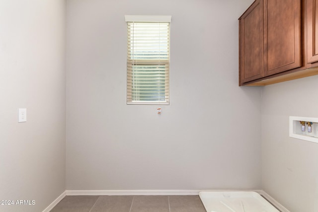 clothes washing area with cabinets, light tile patterned floors, and hookup for a washing machine