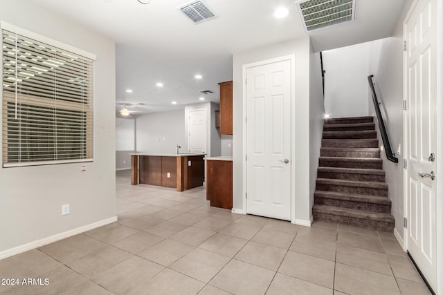 staircase with tile patterned floors and ceiling fan