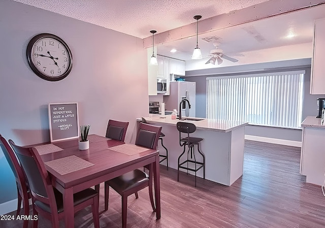 dining room featuring ceiling fan, dark hardwood / wood-style floors, and a textured ceiling