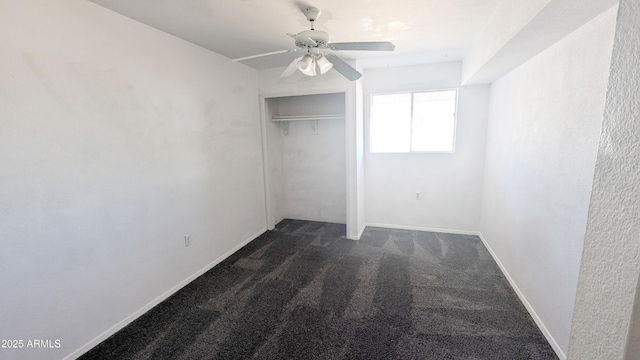 unfurnished bedroom with ceiling fan, a closet, and dark colored carpet