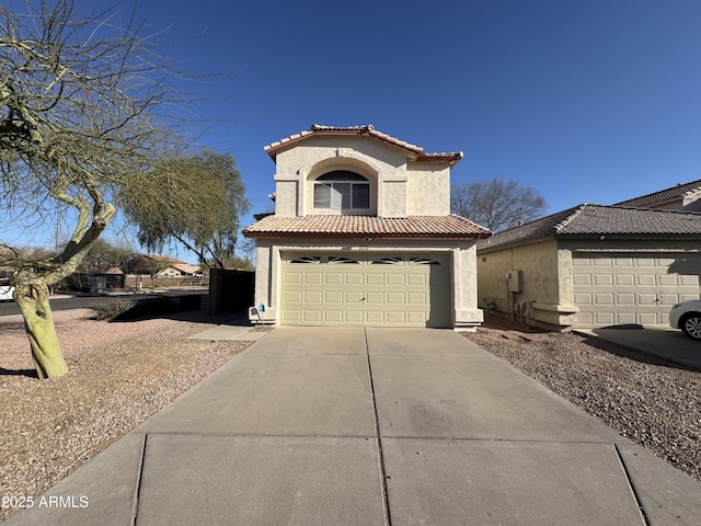 mediterranean / spanish-style home with a tile roof, driveway, and stucco siding