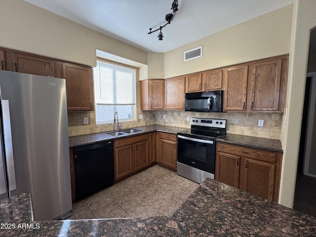 kitchen with decorative backsplash, black appliances, visible vents, and a sink