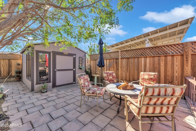 view of patio with a shed and an outdoor fire pit