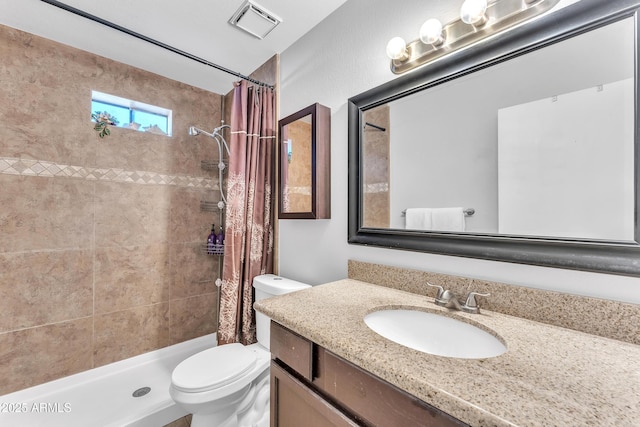 bathroom with curtained shower, vanity, and toilet