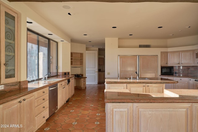 kitchen featuring light brown cabinets, sink, stainless steel dishwasher, an island with sink, and black microwave