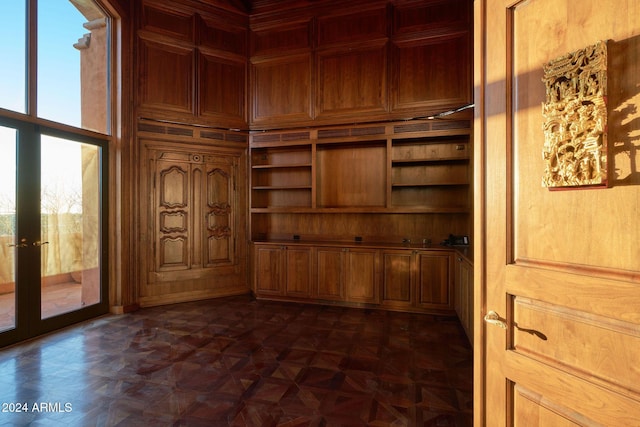 interior space featuring wood walls and dark parquet flooring