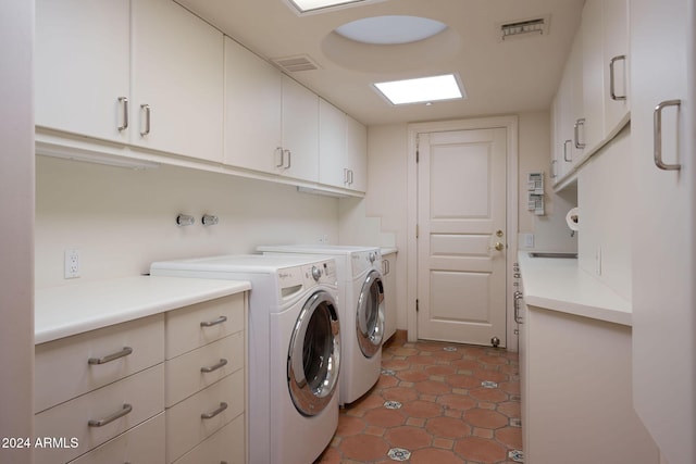 clothes washing area featuring dark tile patterned floors, cabinets, and independent washer and dryer