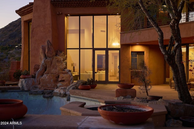 rear view of property featuring a patio area and an outdoor fire pit