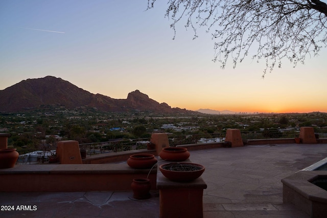 patio terrace at dusk featuring a mountain view