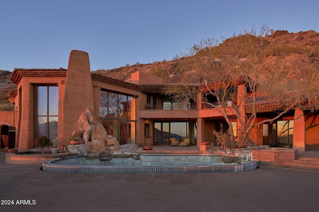 rear view of house with a patio area and a balcony