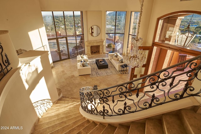 staircase with a premium fireplace and an inviting chandelier