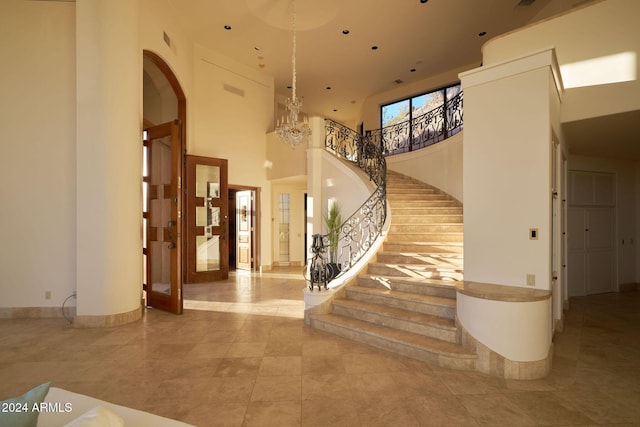 tiled entryway featuring a towering ceiling and an inviting chandelier