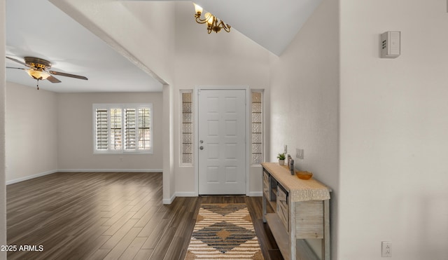 entryway featuring vaulted ceiling, dark hardwood / wood-style floors, and ceiling fan with notable chandelier