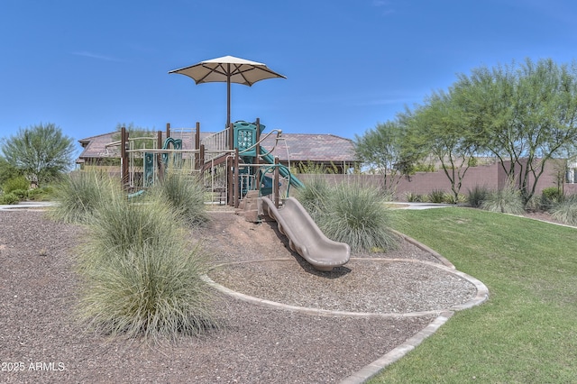 community jungle gym featuring a lawn and fence