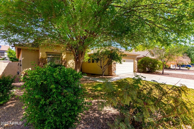 12726 W Charter Oak Rd, El Mirage, AZ 85335 - obstructed view of property featuring an attached garage, driveway, stone siding, and stucco siding