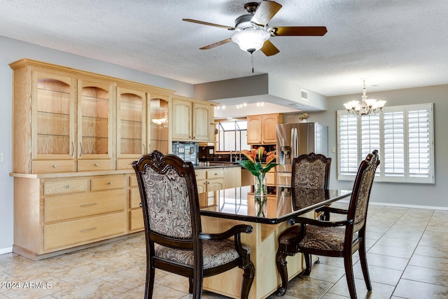 tiled dining room featuring ceiling fan with notable chandelier and a textured ceiling