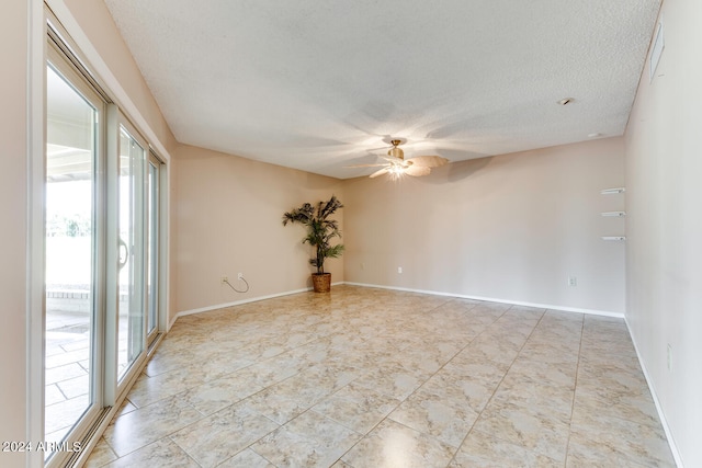 unfurnished room with ceiling fan and a textured ceiling