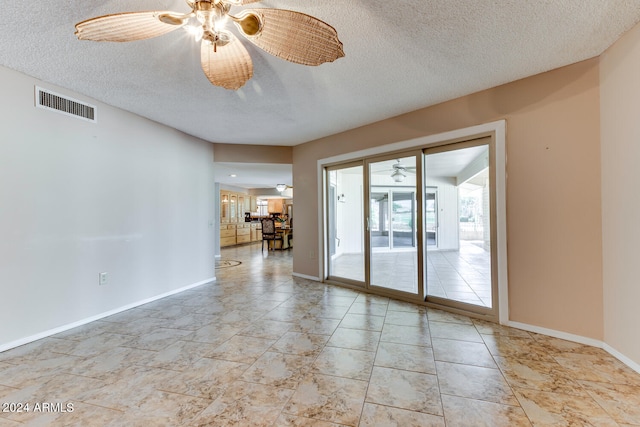 empty room featuring ceiling fan and a textured ceiling