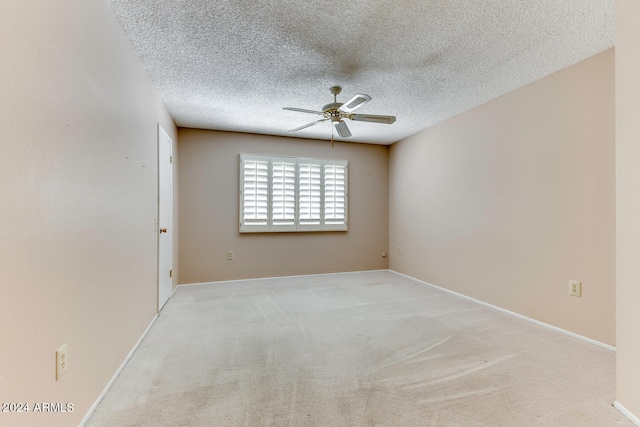 carpeted empty room with ceiling fan and a textured ceiling