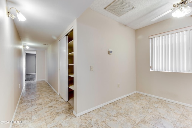 hall featuring a textured ceiling