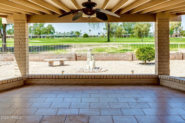 view of patio featuring a water view and ceiling fan