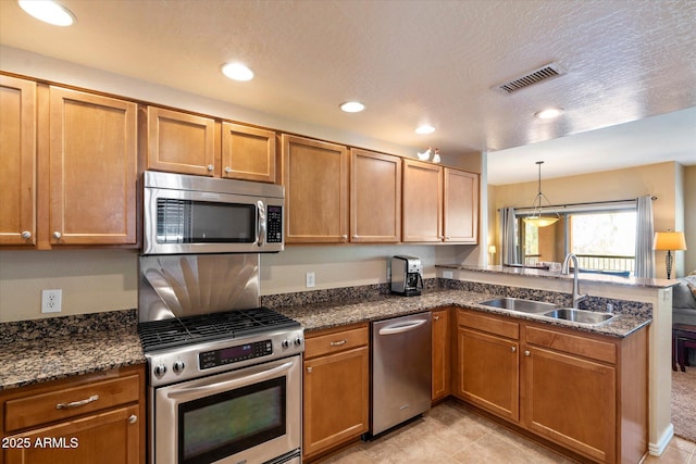 19700 N 76th St Unit 2089, Scottsdale, AZ 85255 - kitchen featuring stainless steel appliances, a peninsula, a sink, visible vents, and brown cabinets