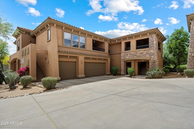 19700 N 76th St Unit 2089, Scottsdale, AZ 85255 - view of front facade with stone siding, concrete driveway, a garage, stairway, and stucco siding