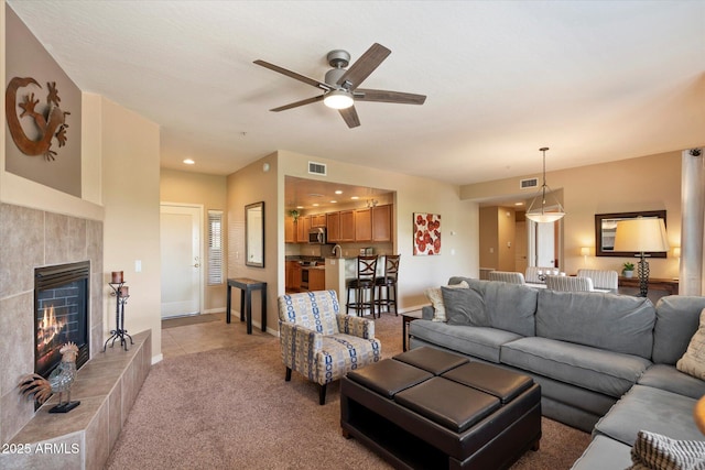 19700 N 76th St Unit 2089, Scottsdale, AZ 85255 - living area featuring a ceiling fan, visible vents, a tile fireplace, and light colored carpet