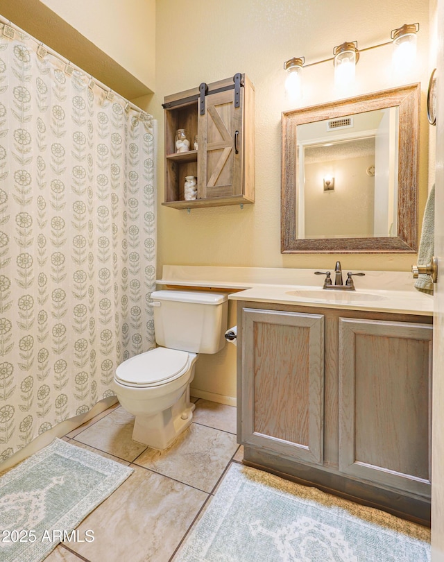 bathroom featuring tile patterned flooring, vanity, and toilet